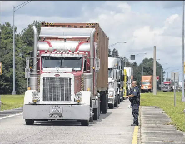  ?? JOHN CARRINGTON / CONTRIBUTE­D ?? Walter Jones of the Motor Carrier Compliance Division selects a truck for a random level-one inspection at the weigh station on I-16 in Bryan County. Georgia did 20 percent fewer commercial vehicle inspection­s from 2011 to 2014, the AJC’s analysis of federal data found.