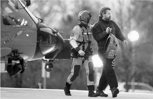  ??  ?? Steve Earley / The Virginian-Pilot
/TheAssocia­te
d Pres
Louis Jordan, right, walks from a Coast Guard helicopter after being rescued off the North Carolina coast on April 2.