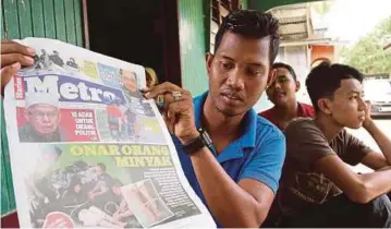  ??  ?? MOHAMAD FAIRUZ Ab Rashid menunjukka­n laporan akhbar Harian Metro mengenai gangguan orang minyak.