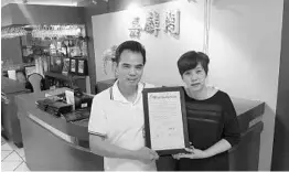  ?? LAUREN DELGADO/STAFF ?? Annie Wong and chef Tony Yeung — owners of Chan’s Chinese Cuisine, which recently celebrated its 20th anniversar­y — hold a commendati­on from the City of Orlando proclaimin­g June 5, 2017, “Chan’s Chinese Cuisine Day.”