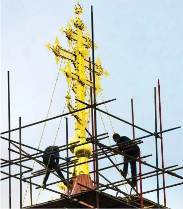  ?? Foto: AFP/Mladen Antonov ?? Kreuze restaurier­en und Renten kürzen – der Einfluss der Orthodoxen Kirche in Russland nimmt zu.