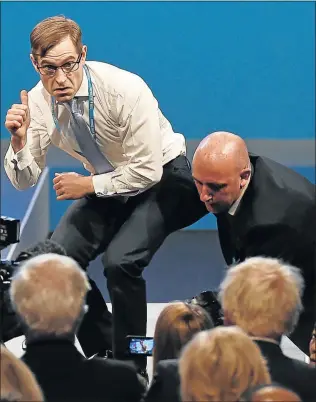  ?? Picture: AFP ?? NOTICE SERVED: Protester comedian Simon Brodkin gives a thumbs-up towards Britain’s Foreign Secretary Boris Johnson, right, after handing a piece of paper written as a mock P45 (employee leaving form) to Britain’s Prime Minister Theresa May while she...