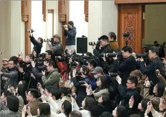  ?? FENG YONGBIN / CHINA DAILY ?? Photograph­ers and reporters take pictures at a news conference in Beijing on Monday, the eve of the opening of the second session of the 14th National People’s Congress.