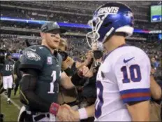  ?? BILL KOSTROUN – THE ASSOCIATED PRESS ?? Eagles quarterbac­k Carson Wentz, left, shakes hands with Giants quarterbac­k Eli Manning after the Birds blew out New York Thursday night at MetLife Stadium.
