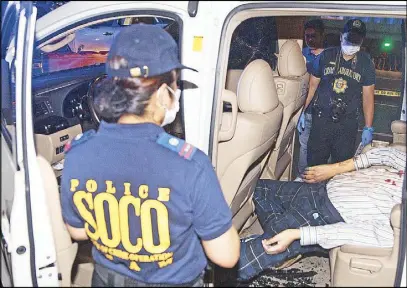  ?? JOVEN CAGANDE ?? Police probers inspect the body of Seiki Mizuno in Manila on Thursday night.