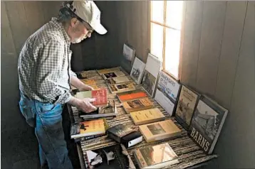  ?? DAVID KELLY/FOR LOS ANGELES TIMES ?? Jeff Lee sets out books at the Rocky Mountain Land Library, which sits in an emerald valley 10,000 feet above sea level.