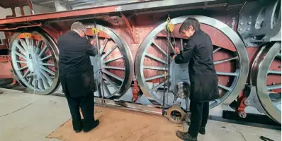  ?? ?? Above: David Elliott and Ed Laxton prepare to lift the first coupling rod to be fitted at Darlington Locomotive Works. A1SLT