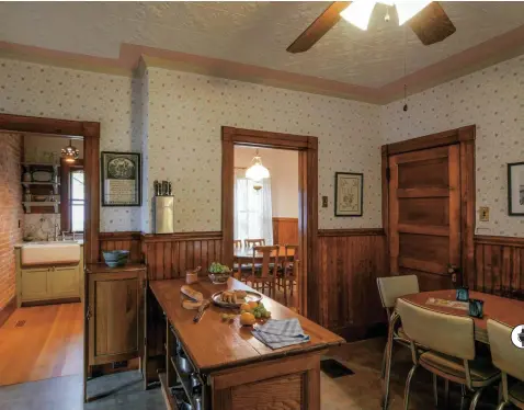  ??  ?? LEFT The kitchen is airy and old-fashioned with a stove at far left, a worktable as an island, and a small dining area to the right. With a big sink, the butler’s pantry functions as a scullery. OPPOSITE (bottom) In the pantry, the pass-through to the...