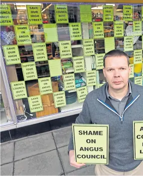  ?? Picture: Gareth Jennings. ?? Bruce Robertson at his hardware store in Brechin, where he has covered a window with posters protesting the council parking charges.