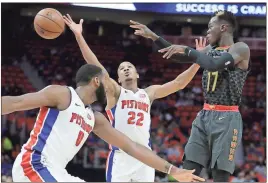  ?? Carlos Osorio / AP ?? Atlanta’s Dennis Schroder (right) passes between Detroit’s Andre Drummond (left) and Avery Bradley during the first half of Friday’s game in Detroit.