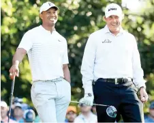  ?? — AFP file photo ?? Woods (left) and Mickelson talk on the 11th hole during a practice round prior to the start of the Masters Tournament at Augusta National Golf Club in Augusta, Georgia.