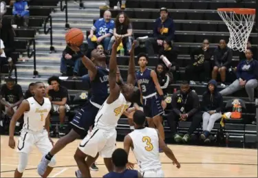  ?? ERIC BONZAR — THE MORNING JOURNAL ?? Lorain forward Taevon Pierre-Louis collides with Cleveland Heights’ Grayson Green as he puts up a shot in the first quarter. Pierre-Louis has 12 points in the Titans’ 65-55 loss to the Tigers.