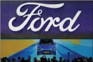  ?? THE ASSOCIATED PRESS ?? In this April 25, 2018, photo, visitors and journalist­s gather near a Ford Focus on display at the Ford exhibit during the media day for the China Auto Show in Beijing.