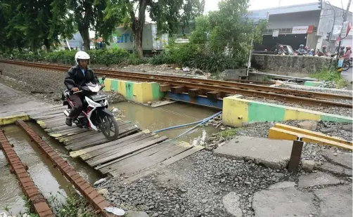  ?? BOY SLAMET/JAWA POS ?? SUDAH LIMA TAHUN: Pengendara sepeda motor melintas di kawasan Sruni yang belum tersambung dengan ruas frontage road di Tebel.