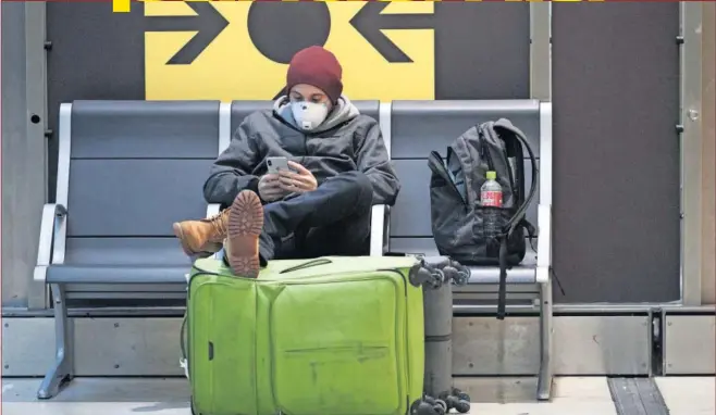  ??  ?? Un pasajero espera su vuelo en la terminal 4 del aeropuerto Adolfo Suárez-Barajas, de Madrid, durante la crisis del coronaviru­s.