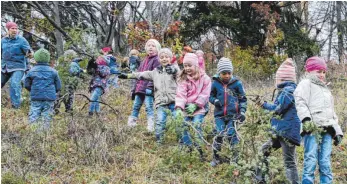  ?? FOTO: HEINZ THUMM ?? In einer langen Kette reichten die jüngsten Schulkinde­r Äste und Zweige am Steilhang weiter, bis diese ins Feuer geworfen wurden.