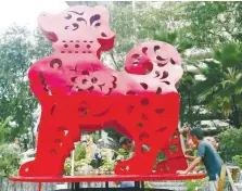  ??  ?? ... Workers putting the finishing touches to a 500kg model of a dog at the Thean Hou Temple in Kuala Lumpur in preparatio­n for Chinese New Year.