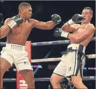  ??  ?? Anthony Joshua forces Joseph Parker back in Cardiff last night