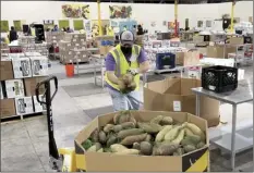  ?? AP photo ?? A worker puts bags of sweet potatoes in a container in the warehouse of the Alameda County Community Food Bank in Oakland, Calif., on Nov. 5. U.S. food banks dealing with increased demand from families sidelined by the pandemic now face a new challenge – surging food prices and supply chain issues. As holidays approach, some food banks worry they won't have enough turkeys, stuffing and cranberry sauce for Thanksgivi­ng and Christmas.