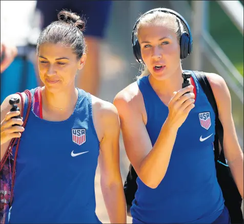  ?? RICHARD HEATHCOTE/GETTY IMAGES ?? Alex Morgan, left, and Allie Long walk into a training session at the Gymnase Parc on Saturday. The U.S. is looking to repeat winning the World Cup and win its 4th overall.
