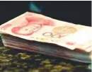  ??  ?? Chinese 100 yuan banknotes are seen on a counter of a branch of a commercial bank in Beijing, China.