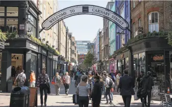  ?? John Keeble / Getty Images ?? Tourists in popular London spots like Carnaby Street do not see anything close to the level of homeless individual­s, trash and open drug use that bedevils San Francisco.