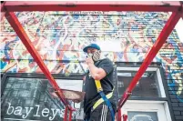  ?? CHRISTOPHE­R KATSAROV THE CANADIAN PRESS ?? Anthony Ricciardi spray paints the eastern facade of a commercial establishm­ent on Bathurst St. in July.