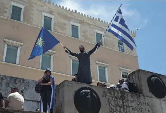  ?? PETROS GIANNAKOUR­IS THE ASSOCIATED PRESS ?? A protest outside the Greek parliament in Athens Friday over the deal between Greece and Macedonia over the former Yugoslav republic’s name. The flag of Greece is on the right. The flag on the left is the Vergina Sun. Vergina is a town in Greek...