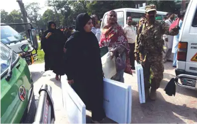  ??  ?? Election presiding officers carry election materials for a by-election after receiving them from the distributi­ng point in Lahore yesterday. More than 100 candidates are contesting for 35 National Assembly and Provincial Assembly seats in the by-election scheduled for today.