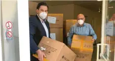  ?? Foto: R. Gramm ?? Rolf Gramm (rechts) übergibt Masken an die Theresia-Hecht-Stiftung. Seine Zulieferer in China haben ihm 40000 Exemplare geschickt.