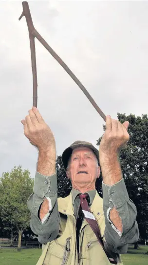  ?? STEVE PORTER
AN143764 ?? Waverley Dowsers founder member Mike Haxeltine demonstrat­es the ancient art at King George V Playing Fields, in Sycamore Road, Farnboroug­h.