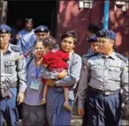  ?? AUNG KYAW HTET/AFP ?? Reuters journalist Kyaw Soe Oo (centre) carries his daughter while walking in handcuffs after a bail hearing at a courthouse in Yangon yesterday.