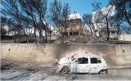  ??  ?? Stark landscape: A burnt-out car in Mati, Greece yesterday