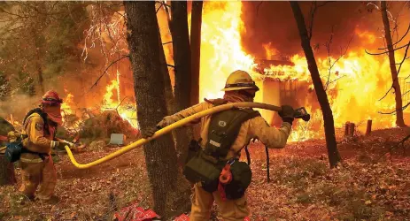  ??  ?? Bomberos trabajan para sofocar el incendio, en Magalia, que en más de 24 horas ha arrasado 28 mil hectáreas.