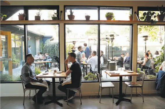  ?? Photos by Carlos Avila Gonzalez / The Chronicle ?? The view from the interior dining room to the courtyard dining area at Top Hatters, a new restaurant in San Leandro with a CalVietnam­ese menu.