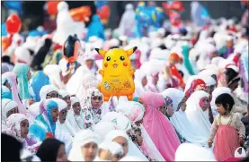  ?? Pictures: REUTERS ?? BRIGHT AND COLOURFUL: Women and children attend an Eid ul-Fitr mass prayer at Sunda Kelapa port in Jakarta, Indonesia. Egyptians celebrate and try to catch balloons released after the prayers that brought Ramadaan to a close, at a public park, outside...