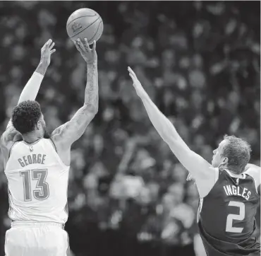  ?? [PHOTO BY SARAH PHIPPS, THE OKLAHOMAN] ?? Oklahoma City’s Paul George shoots over Utah’s Joe Ingles during Game 1 in the first round of the NBA playoffs Sunday at Chesapeake Energy Arena.