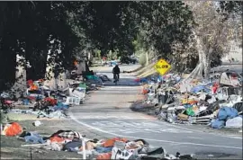  ?? Allen J. Schaben Los Angeles Times ?? A BICYCLIST rides along the Santa Ana River trail, from which hundreds of homeless people have been resettled into Orange County motels and shelters.