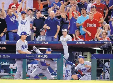  ?? RICK SCUTERI/ASSOCIATED PRESS ?? Cody Bellinger of the Los Angeles Dodgers tumbles into the dugout after catching a foul popup during Monday night’s National League Division Series game in Phoenix. The Dodgers swept the best-of-five series.