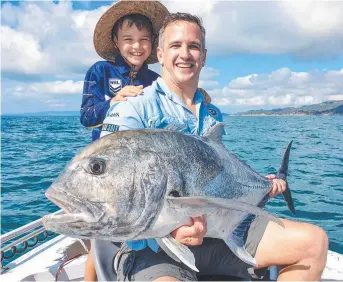  ?? ?? Phillip Wolanski released this hug GT or giant trevally while son Oliver watched on.