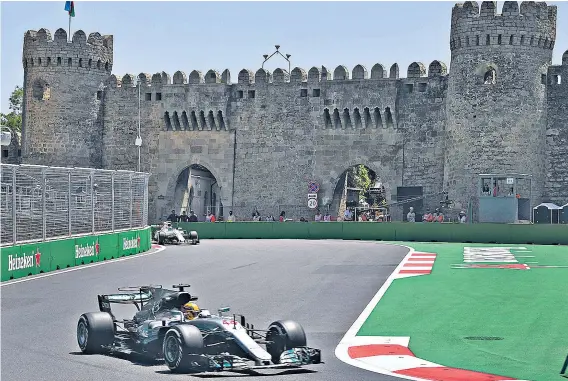  ??  ?? Picture perfect: Baku’s castle forms an impressive backdrop as Lewis Hamilton races in yesterday’s practice session and (below) the Briton in the paddock