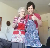  ??  ?? Elsie Langhorne in her omni-present apron alongside grandson Cory Churko, modeling another of her smocks.