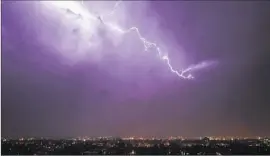  ?? David Zalubowski
Associated Press ?? LIGHTNING FLARES over downtown Denver. A hiker was struck and killed this month, the first fatality in a string of Colorado lightning strikes.