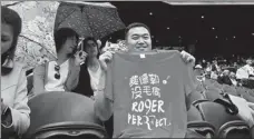  ?? AFP ?? A spectator displays a T-shirt supporting Roger Federer at Wimbledon’s Centre Court on Monday. The Chinese characters translate as: Roger Federer, perfect.