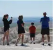  ??  ?? A family stops to capture a moment in South Dakota’s Badlands National Park.