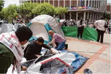  ?? Don Feria/Special to the Chronicle ?? Protesters set up tents and supplies on Monday for an encampment outside Sproul Hall on the UC Berkeley campus.