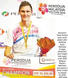  ?? - AFP photo ?? Denmark’s Viktor Axelsen poses on the podium after defeating Kenta Nishimoto of Japan during their men’s singles final match at the 2018 Malaysia Masters badminton tournament in Kuala Lumpur on January 21, 2018.
