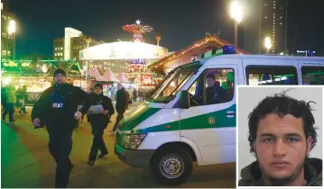  ?? (Reuters) ?? POLICE ARE seen at a Christmas market in Berlin yesterday. Police suspect Anis Amri (inset) was involved in the truck attack in the city on Monday.