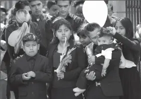  ?? AL SEIB/LOS ANGELES TIMES ?? The oldest child, second from left, with the youngest of the six children, left, and family mourn during the funeral services at Our Lady of Guadalupe Church on April 2 in Delano for Santos Hilario Garcia and Marcelina Garcia Profecto, who were killed...