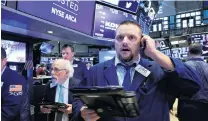  ?? PHOTO: REUTERS. ?? Index plunge . . . Traders on the floor of the New York Stock Exchange in Manhattan, New York, watch on Wednesday as its three benchmark indexes head into negative territory.